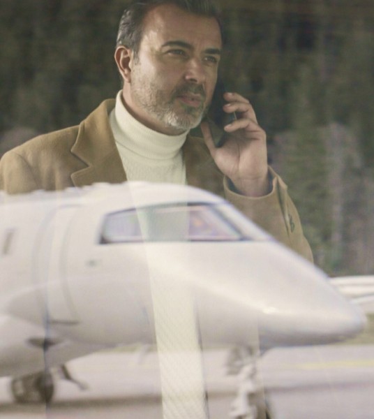 Homme au téléphone regardant un avion Pilatus PC-24