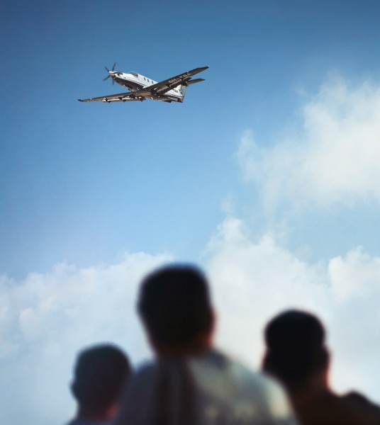 Un Pilatus PC-12 volant au-dessus de nos têtes dans un ciel bleu, vu d’en bas