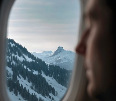 Vue de montagnes enneigées depuis le hublot d’un avion