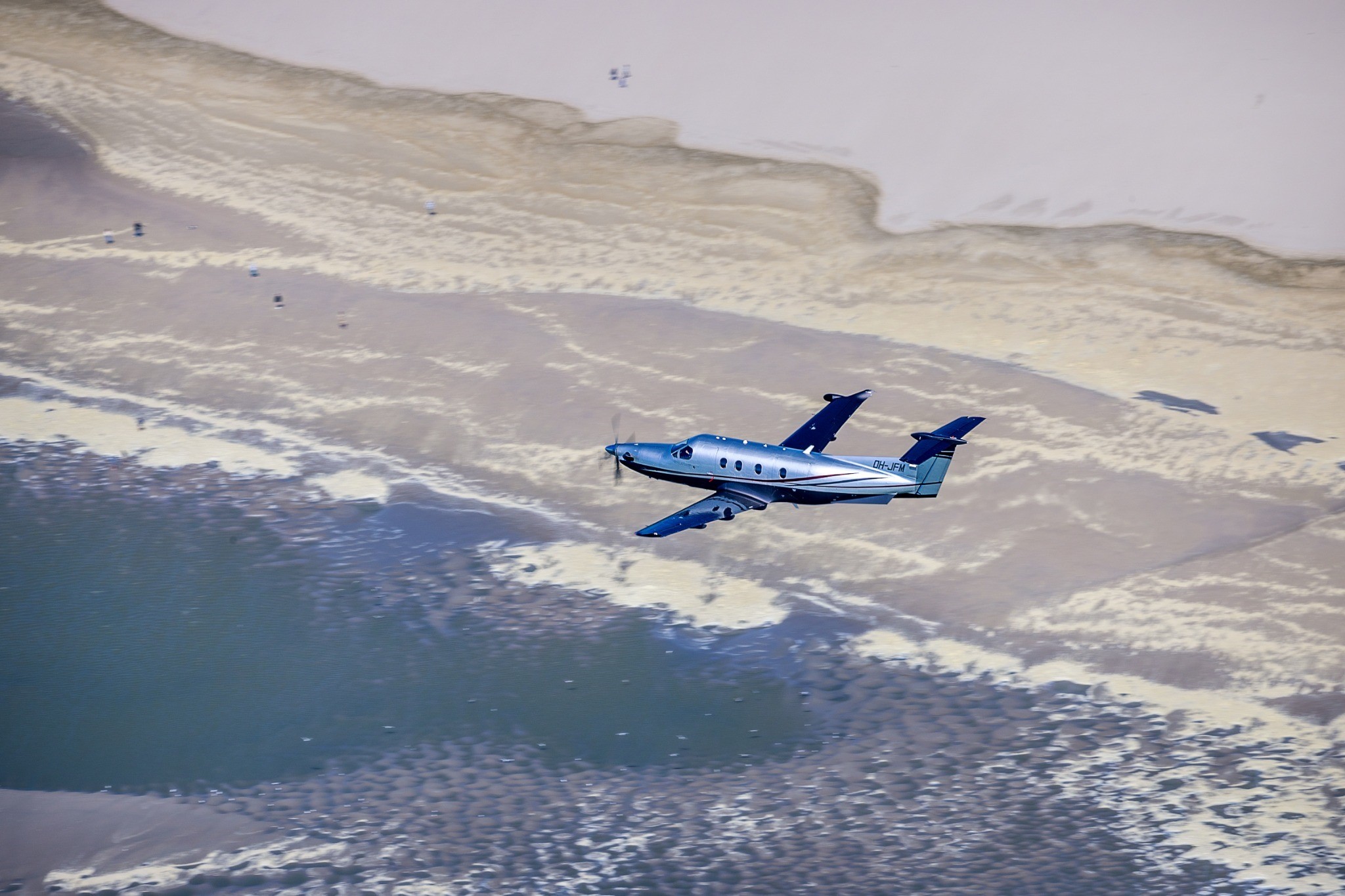 Pilatus PC-12 survolant une plage