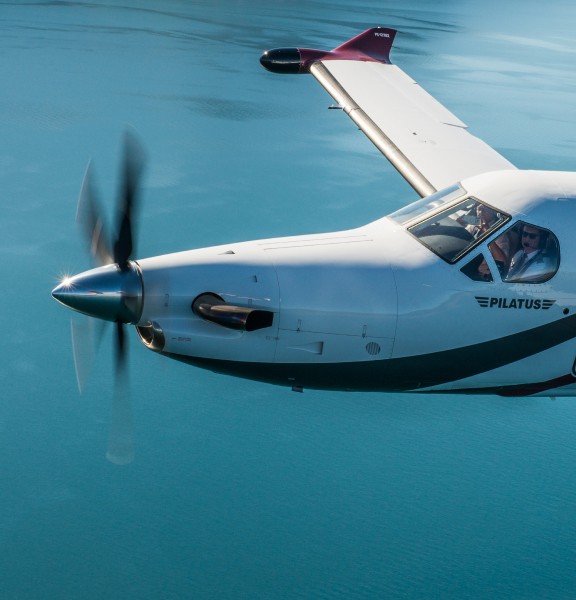 Gros plan de pilotes volant à bord du Pilatus PC-12 au-dessus d’un lac